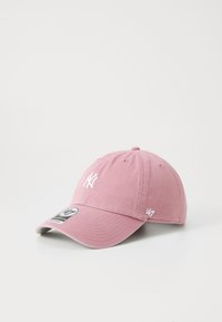 Cappello in cotone rosa con visiera curvata, dotato di un logo ricamato bianco sulla parte frontale e un'etichetta '47' sul lato. La texture è liscia.