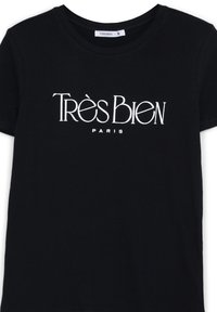 T-shirt in cotone nero con maniche corte, con testo bianco che recita "Très Bien PARIS" in un font stilizzato e in evidenza.