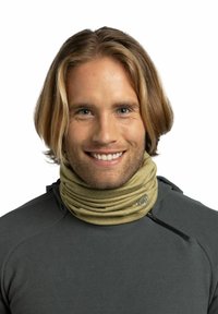 Buff neck gaiter in soft, beige fabric, featuring a snug, tubular design. Worn around the neck, paired with a dark gray fleece top.