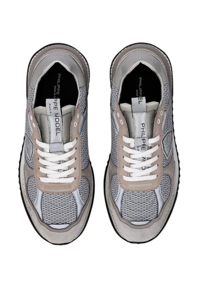 Sneakers con tomaia in rete grigia e beige, dotate di lacci bianchi e suola in gomma nera. Gli accenti notevoli includono pannelli in suede e testurizzati.