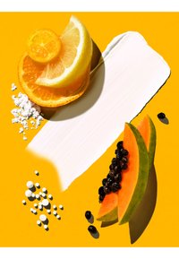 Fette di limone, arancia e papaya con semi neri su sfondo giallo accanto a una crema bianca spalmabile e piccoli pellet bianchi.