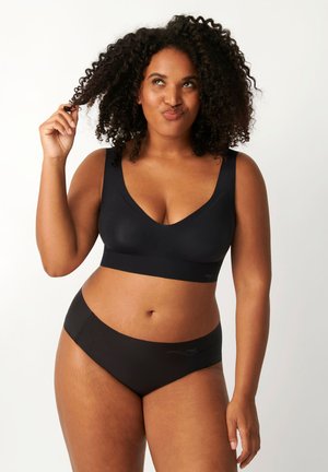 Bralette noir sans couture avec un décolleté en V profond et des bretelles larges, associé à un slip noir assorti avec une texture lisse et douce et un branding minimal.