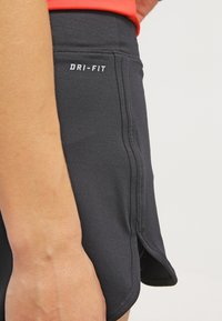 Shorts de running Dri-FIT en negro con textura suave, que cuentan con aberturas laterales, un ajuste ceñido y logotipo en blanco en la cinturilla.