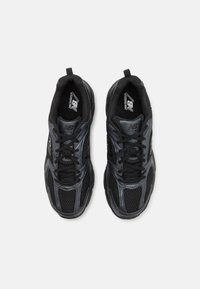 Zwarte sportieve schoenen met een bovenwerk van mesh en synthetische accenten. Heeft een vetersluiting en een gestructureerde zool voor grip.