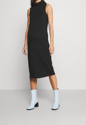 Robe midi noire sans manches, ajustée, avec col roulé, associée à des bottes à talons bleu clair mi-mollet, sur un fond clair uni.