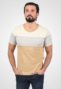 Beige og grå farveblokeret kortærmet t-shirt med rund halsudskæring. Har en glat bomuldsstof og et subtilt horisontalt linjemønster.