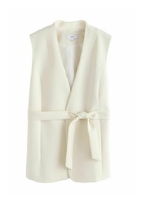 Cream sleeveless blazer with a V-neck, belted waist, smooth fabric, and a classic tailored shape. No visible buttons or hardware.