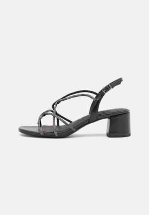 Sorte læder sandaler med blokhæle, crisscross stropper og metallic perle detaljer. Justerbar ankelrem med spænde.