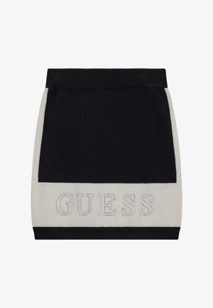 Adīta melna un krēmkrāsas mini svārku ar ribotu jostas daļu. Tam ir "GUESS" logs kontrastējošā diegā uz krēmkrāsas paneļa. Gluda tekstūra.