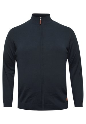 Maglione zip-up navy con colletto alto, polsini e orlo a costine. Presenta una texture liscia e un piccolo dettaglio in pelle marrone nella parte inferiore.