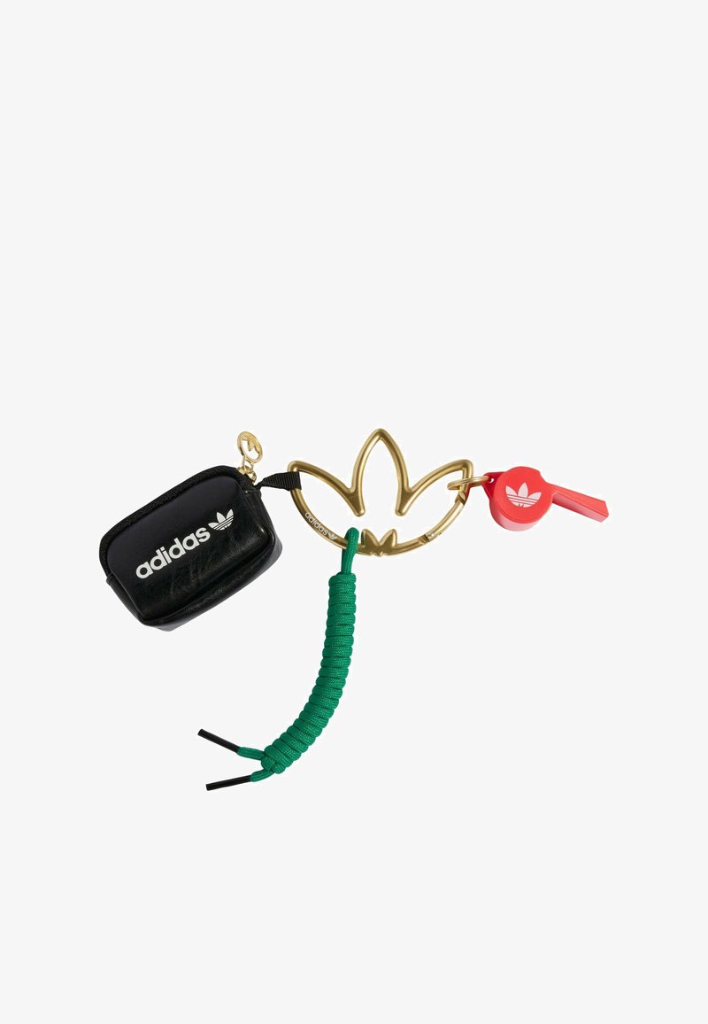 Zwart ritstasje met gouden Adidas-logo, gouden bloem sleutelhanger, rode fluit en groene gecoilde koordaccenten. Duurzame materialen en modern design.