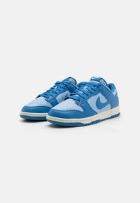 Blå lædersneakers med perforeret tå, kontrasterende lyseblå detaljer, hvid mellemsål og tekstureret gummisål.