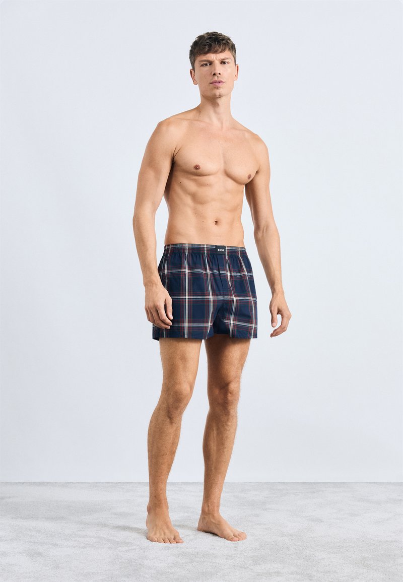 Boxer da uomo a quadri in cotone di colore blu marine, con righe rosse e verdi, vita elastica e vestibilità comoda.