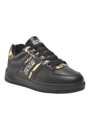 Baskets en cuir noir avec une surface texturée, présentant un panneau latéral à motifs jaunes et blancs et des lacets noirs. Logo de marque en gras sur la languette.