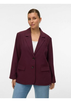 Bordeaux blazer met een kraag, twee voorzakken en twee knopen. De stof heeft een gladde textuur en een gestructureerde pasvorm. Gecombineerd met lichtblauwe jeans.