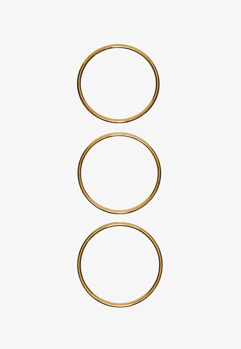 Trois boucles d'oreilles anneaux en or simple disposées verticalement sur fond blanc.