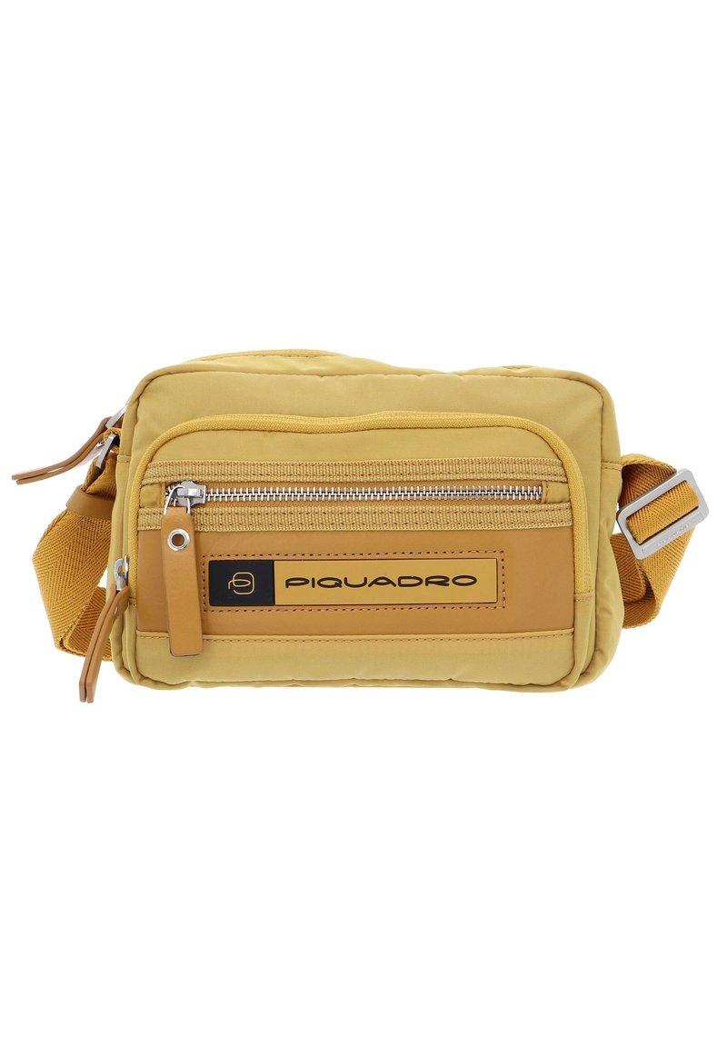 Borsa a tracolla in tessuto giallo con design trapuntato, dotata di una tasca frontale con zip, dettagli in pelle e tracolla regolabile. Logo del marchio visibile.