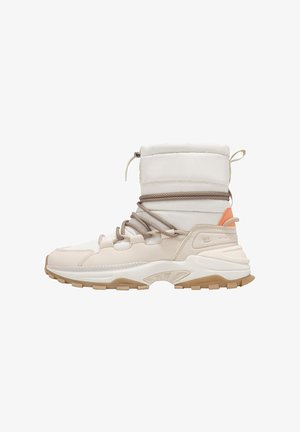 Zapatilla alta en color beige y blanco con tobillo acolchado, cordones marrones y acento naranja. Presenta materiales texturizados y una suela de goma resistente.