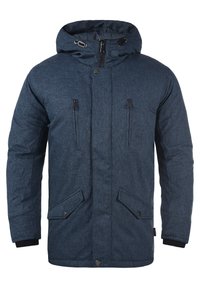 Marineblauwe geïsoleerde jas met een getextureerde afwerking, kap, twee met rits afsluitbare borstzakken en twee met knopen afsluitbare voorzakken. Zwarte accenten bij de manchetten.