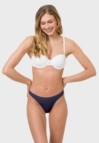 White padded bra with adjustable straps paired with navy blue bikini bottom. Smooth texture, simple design, and form-fitting shape.