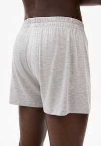 Shorts en coton gris avec une texture douce, taille élastique et coupe décontractée. Présente un design simple et minimaliste sans motifs.