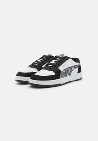 Baskets noires et blanches avec des matériaux en daim et en cuir, présentant un motif de serpent texturé sur le côté, un bout rond et un design à lacets.