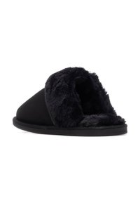 Zapatilla negra con un suave forro de pelaje, un exterior elegante y una suela de goma plana. El diseño presenta una puntera redondeada con un perfil bajo.