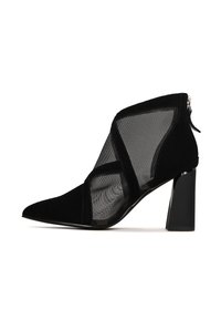 Stivaletto nero con una combinazione di materiali scamosciati e mesh, punta affusolata e tacco a blocco. Chiusura con zip sul retro.