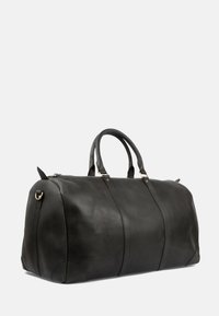 Schwarze Lederreisetasche mit glatter Textur, abgerundeter Form, zentralen Nahtdetails, zwei oberen Griffen und goldfarbenen Metallakzenten.