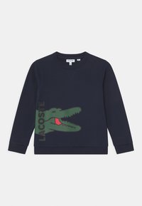 Navy sweatshirt med rundad halsringning, ribbade muddarn och fåll. Har en stor grön krokodil-logotyp med röda detaljer på framsidan.
