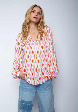 Langärmlige, mehrfarbige Bluse aus leichtem Stoff, die ein auffälliges abstraktes Muster mit pinken, orangen und türkisfarbenen Formen zeigt.