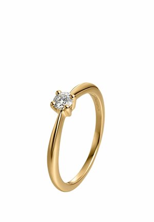 Anillo de oro con un único diamante redondo en un engaste de cuatro garras y una banda lisa y pulida.