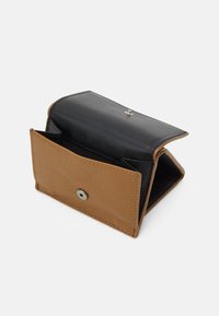 Gefaltete Geldbörse mit schwarzem Lederoberteil und strukturiertem, braunem Lederunterteil. Verfügt über einen Druckverschluss und ein offenes Innenfach.