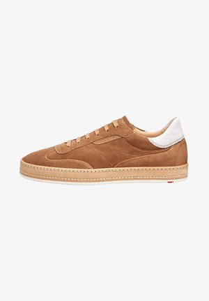 Bruine suède lage sneaker met beige zool en witte leren hielstuk, met veters en gedetailleerde stiksels op de zijpanelen.