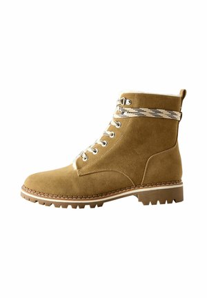Bottine en daim marron à lacets, avec doublure en laine polaire blanche, lacets à motifs et semelle en caoutchouc épaisse.