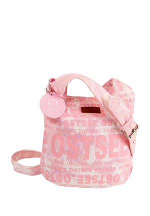 Roze canvas tas met grote "OSTSEE" tekstpatroon, een afneembare ronde tag en dubbele handvaten met een verstelbare schouderriem.