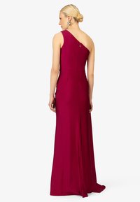 Fuchsia Ein-Schulter-Kleid mit tailliertem Oberteil, fließendem Rock und Reißverschluss auf der Rückseite. Besitzt eine glatte Textur und einen schwingenden Saum.