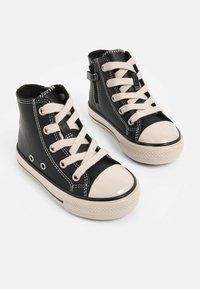 Sorte høj-top sneakers lavet af syntetisk læder, med beige snørebånd, gummitåhætte og kontrasterende hvid stikning.