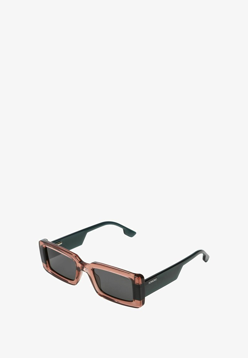 Lunettes de soleil carrées avec une monture transparente de couleur rose et des verres sombres. Caractéristiques des branches noires au design épuré et avec des accents minimaux.