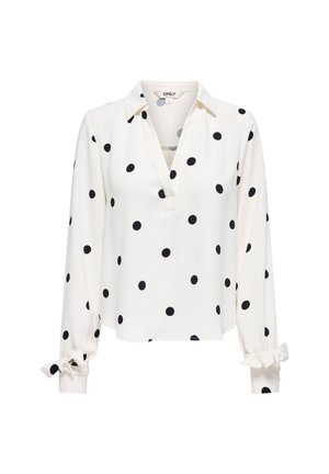 Blouse blanche à manches longues avec des pois noirs, col en V et nœuds aux poignets.