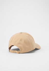 Beige katoenen baseballcap met een gebogen vizier, verstelbare achterband en gestikte details op de kroon. Zachte textuur; achteraanzicht weergegeven.