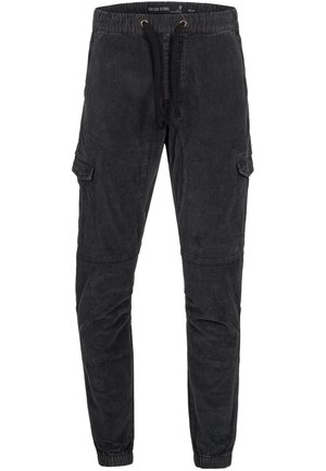 Pantaloni cargo neri con vita elastica, dettaglio con coulisse, tasche laterali e gambe affusolate. Realizzati in un tessuto testurizzato con una finitura sbiadita.
