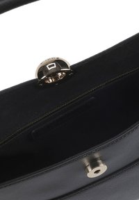 Črna usnjena torbica z gladko teksturo, z zlatim zaponkom in notranjostjo z zadrgo. Podloga je iz temnega blaga, ki poudarja preprostost.