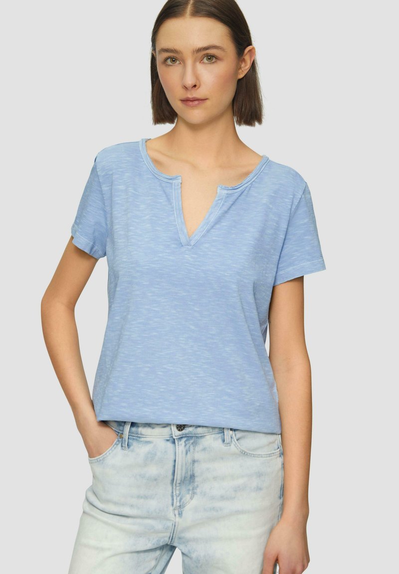  lichtblauw T-shirt met korte mouwen, een v-hals en een relaxte pasvorm. Gemaakt van zachte stof met een subtiele textuur en een vage patroon.