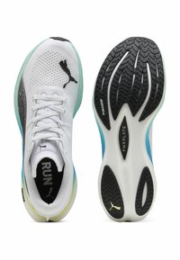 Baskets de course blanches avec une tige en mesh, un logo noir, des accents verts et bleus, et une semelle en caoutchouc noir texturé portant la mention "PWRGRIP".