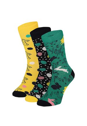 Drei bunte Socken mit unterschiedlichen Mustern: gelb mit Hasen, schwarz mit mehrfarbigen Punkten und grün mit Hasen und Ostereiern.