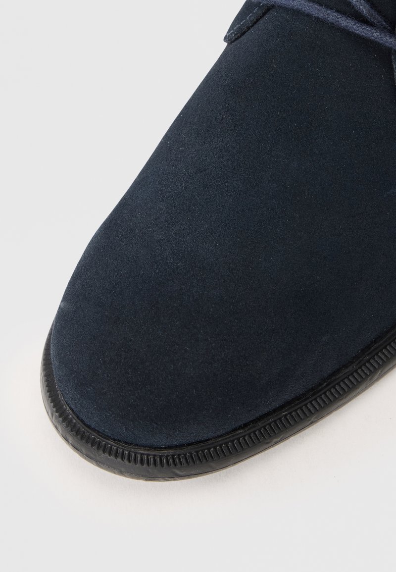 Navyblaue Wildlederschuhe mit runder Spitze und strukturiertem Gummisohle, ausgestattet mit tonalen Schnürsenkeln und einer glatten Oberfläche.