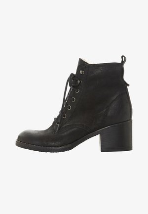 Bottine noire en cuir et en suède, avec un laçage à l'avant, un bout rond et un talon épais. Conçue avec une doublure intérieure douce.