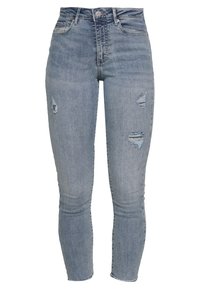 Vaqueros de denim ajustados en azul claro, con detalles desgastados y rotos en la parte frontal, cintura alta y corte ajustado a lo largo de las piernas.
