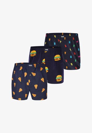 Three black boxer shorts with colorful prints of pizza slices, hamburgers, and gummy bears arranged side by side.